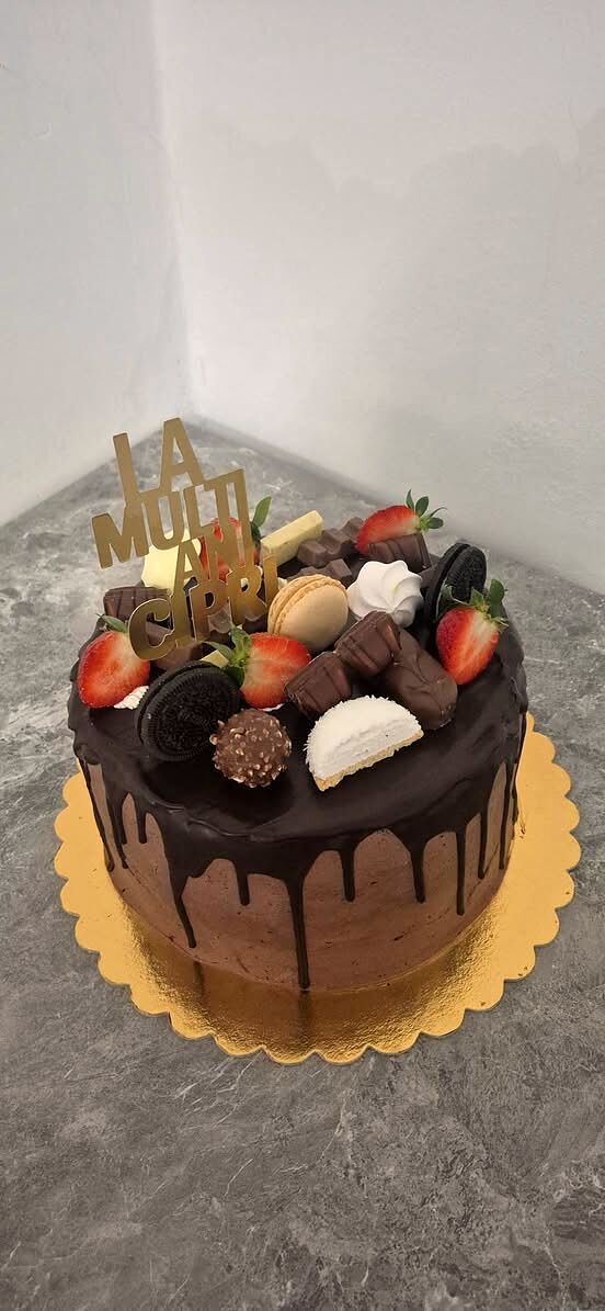 Tort cu glazură de ciocolată, căpșuni, macarons și bomboane